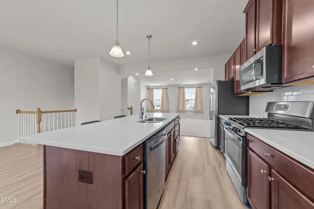 a kitchen with stainless steel appliances granite countertop a sink stove and cabinets