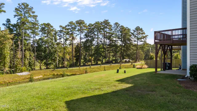 a view of swimming pool with lawn chairs and iron fence