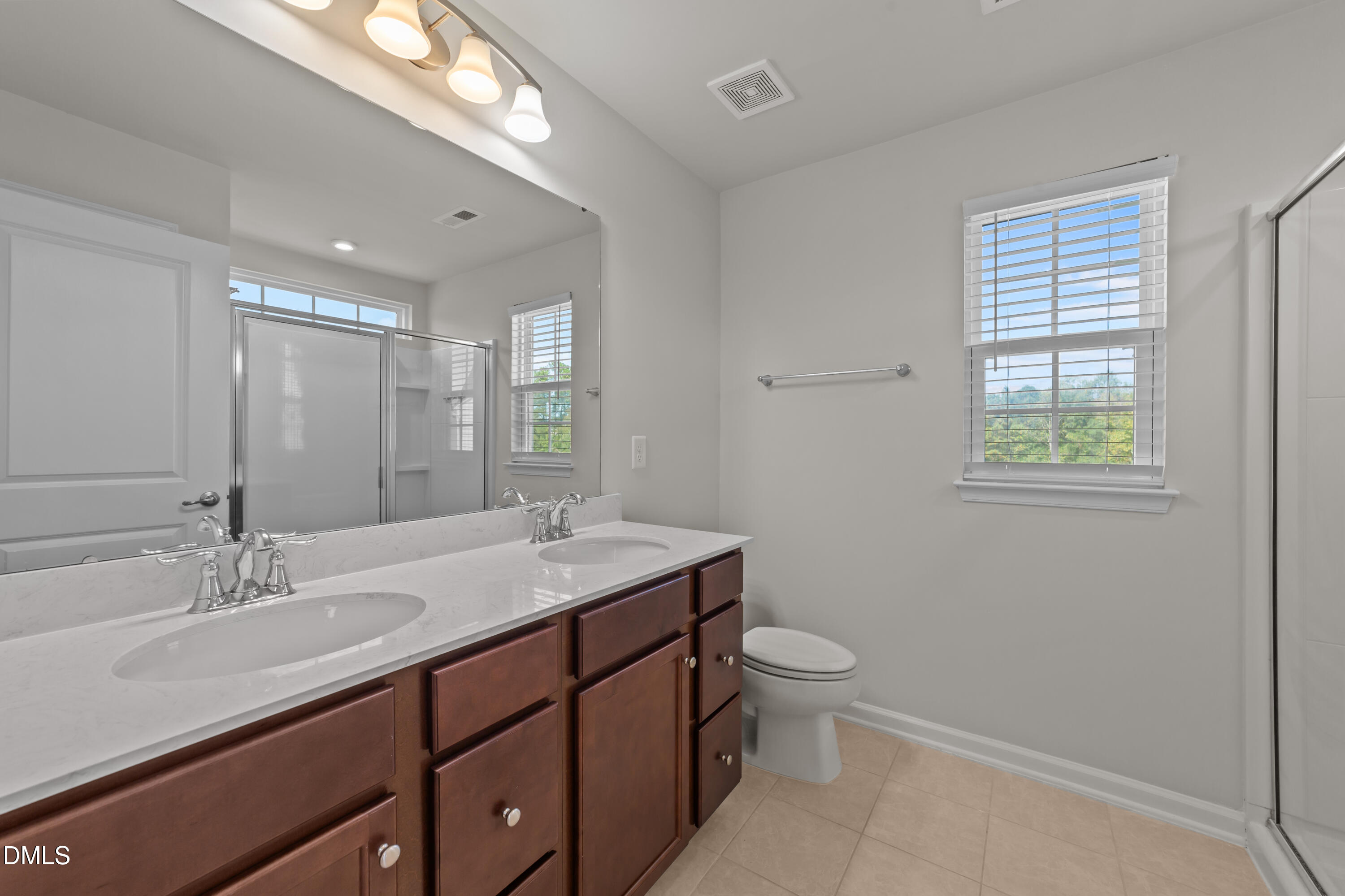 354 Amber Acorn Avenue Raleigh, NC 27603 - Photo 39 of 47 a bathroom with a double vanity sink toilet and a mirror
