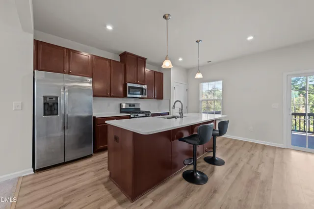 a kitchen with kitchen island a wooden floor and a refrigerator