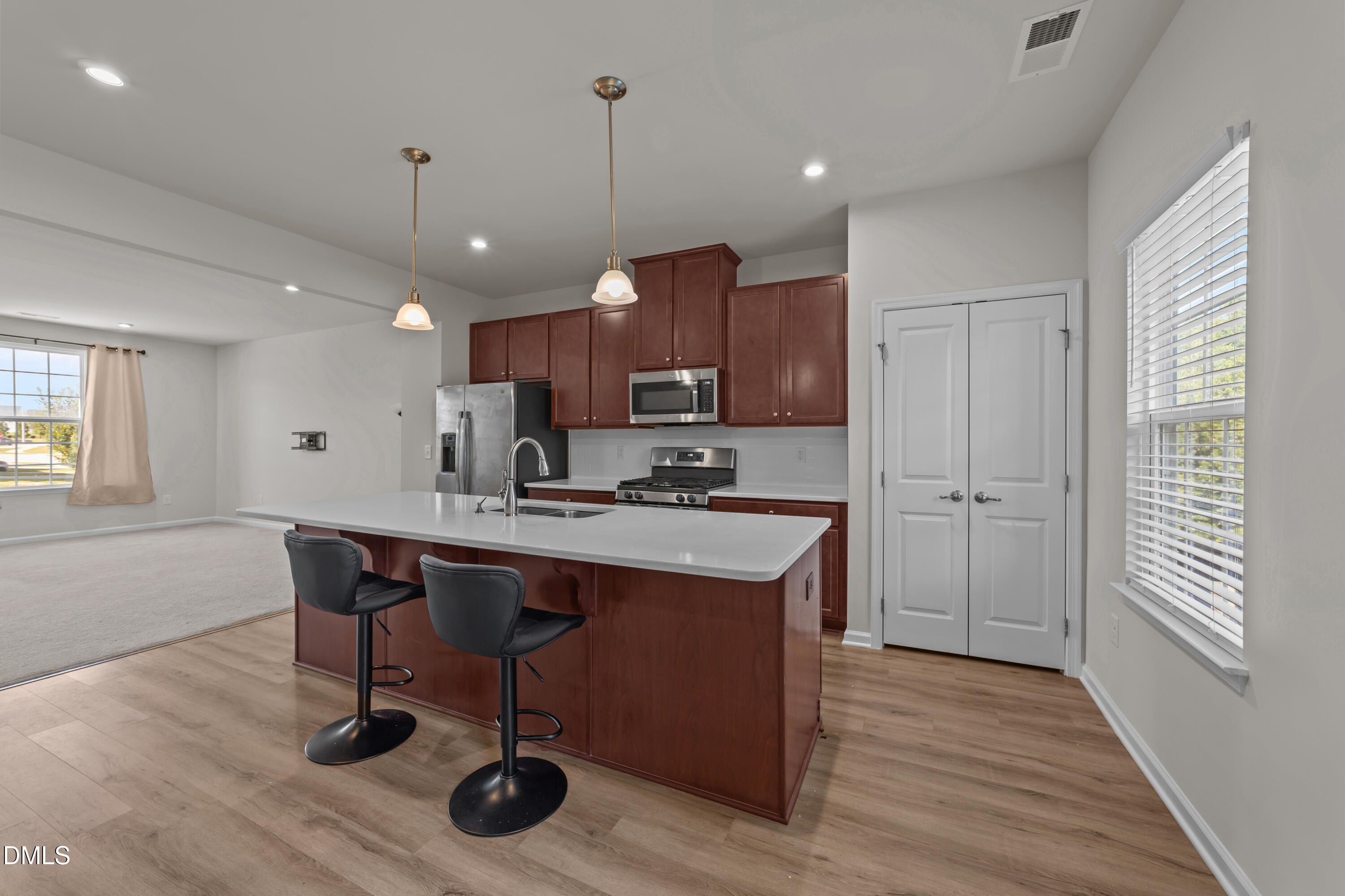 354 Amber Acorn Avenue Raleigh, NC 27603 - Photo 7 of 47 a kitchen with stainless steel appliances granite countertop a sink a stove a refrigerator cabinets and wooden floor