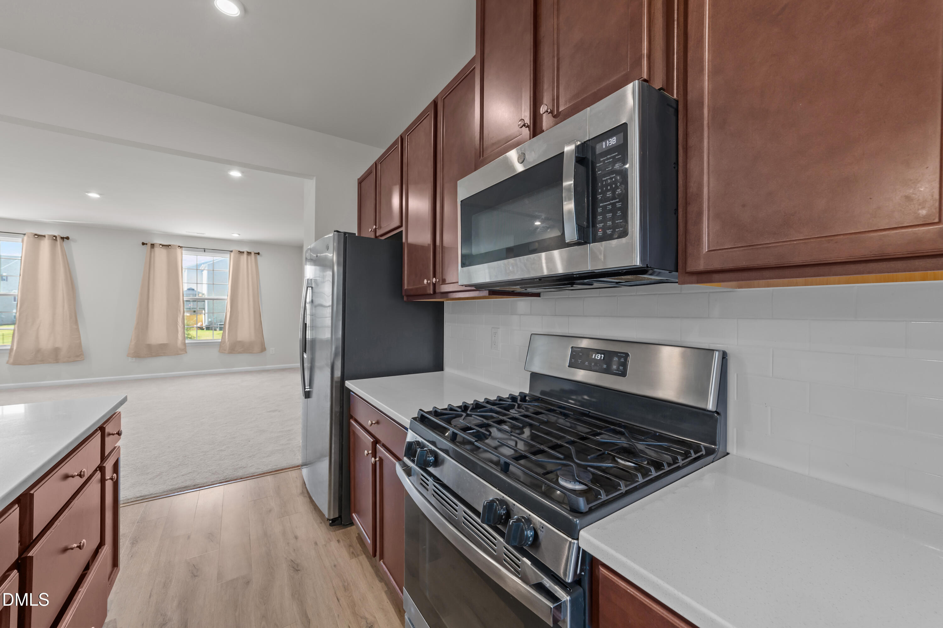 354 Amber Acorn Avenue Raleigh, NC 27603 - Photo 8 of 47 a kitchen with stainless steel appliances granite countertop a stove microwave and sink