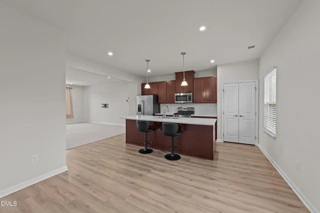 a living room with kitchen furniture and a wooden floor