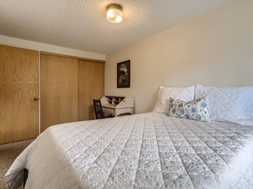 52 Club House Road, Unit 56 Breckenridge, CO 80424 - Photo 14 of 25 a bedroom with a large bed and a lamp on dresser