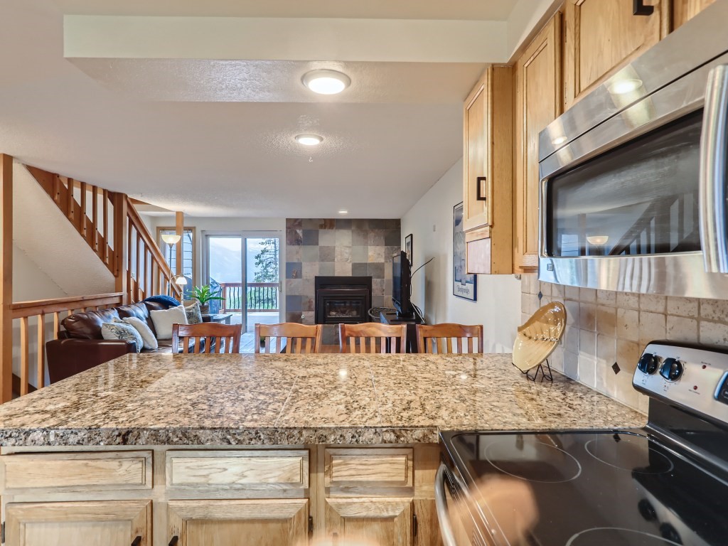 52 Club House Road, Unit 56 Breckenridge, CO 80424 - Photo 7 of 25 a kitchen with stainless steel appliances granite countertop a sink a stove and a wooden cabinets