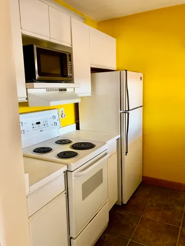 a view of a kitchen with a sink and a refrigerator