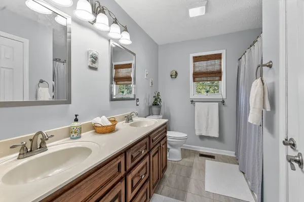 a en suite bathroom with a double vanity sink mirror and shower
