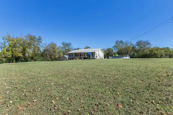a view of a green field with trees in the background