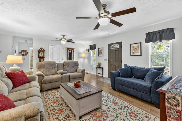 a living room with furniture a rug and a window