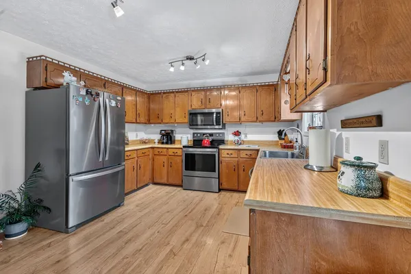 a kitchen with granite countertop stainless steel appliances and wooden cabinets