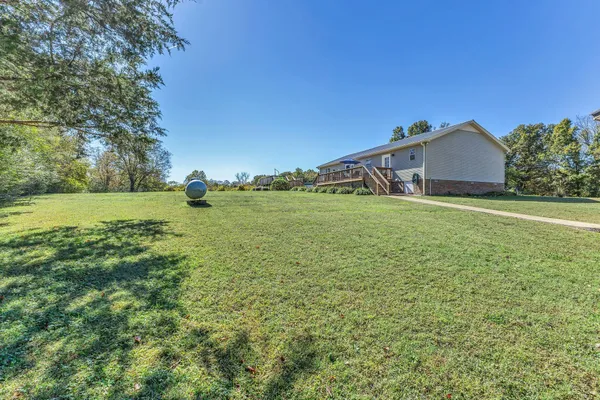 a big yard with lots of green space and house in the back