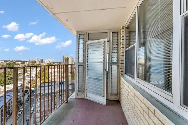 a view of a balcony with floor to ceiling window wooden floor and fence