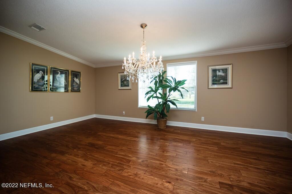 105 South Lake George Drive Georgetown, FL 32139 - Photo 17 of 71 a view of an empty room with wooden floor and a chandelier
