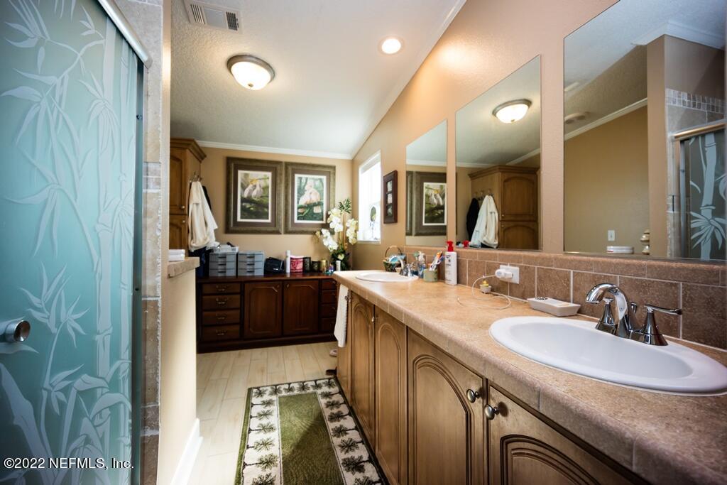 105 South Lake George Drive Georgetown, FL 32139 - Photo 34 of 71 a bathroom with a granite countertop sink a mirror a vanity and a shower