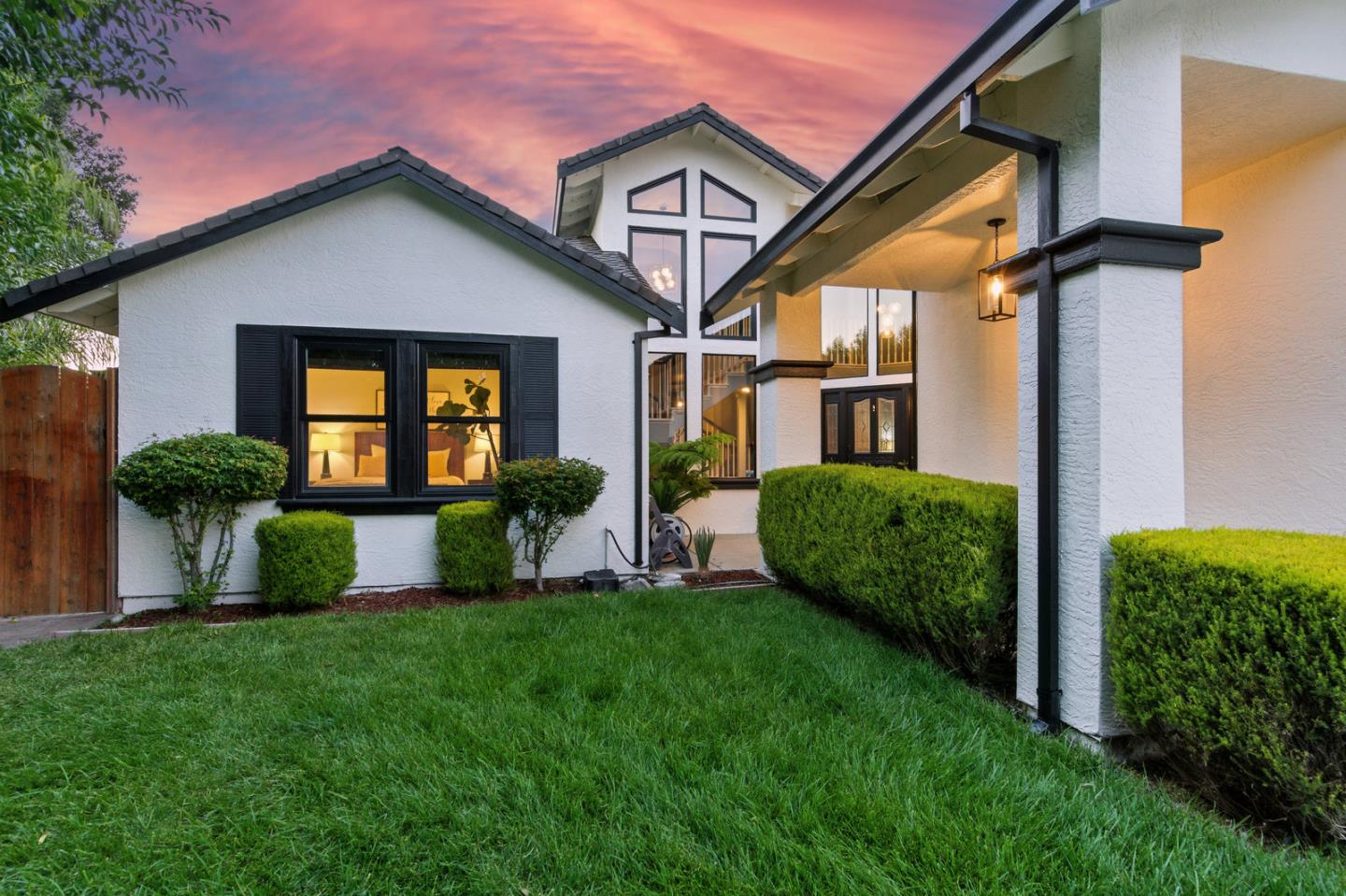 a front view of a house with a yard and potted plants