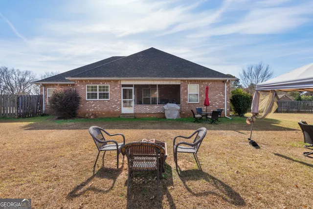 a view of a house with backyard sitting area and garden