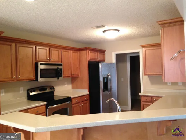 a kitchen with a refrigerator and a stove top oven