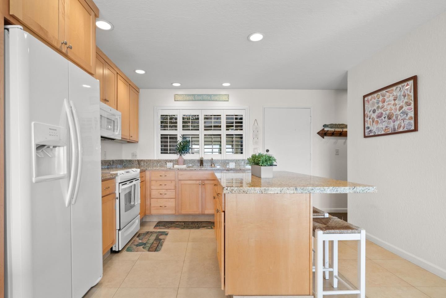 101 Shell Road, Unit 208 Watsonville, CA 95076 - Photo 12 of 26 a kitchen with stainless steel appliances kitchen island granite countertop a refrigerator and a stove top oven