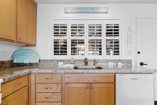 a kitchen with granite countertop a sink and cabinets