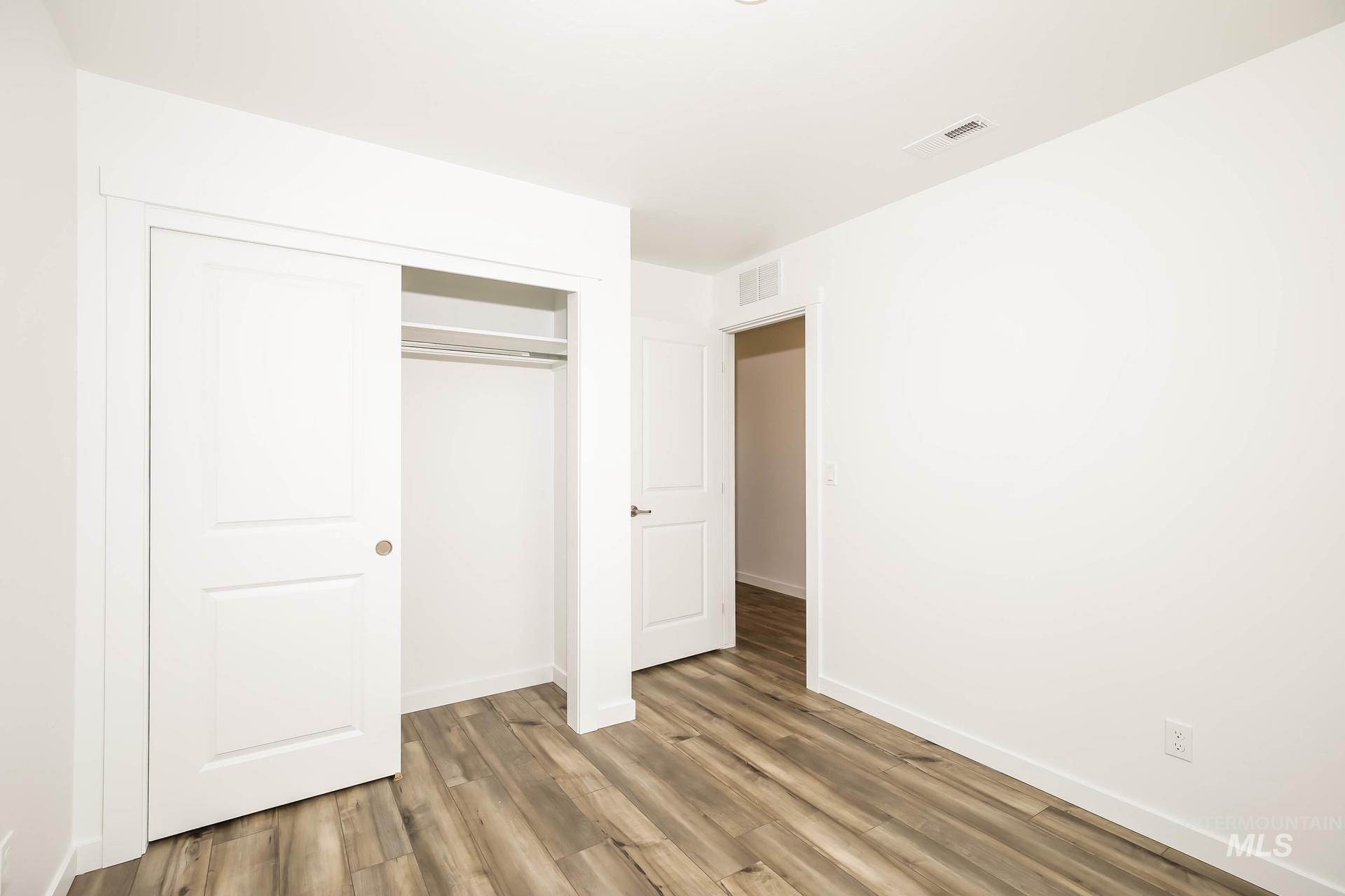 1918 East Springloyd Street Meridian, ID 83642 - Photo 8 of 20 Room featuring wood-finish flooring, white walls, and a built-in closet with sliding doors