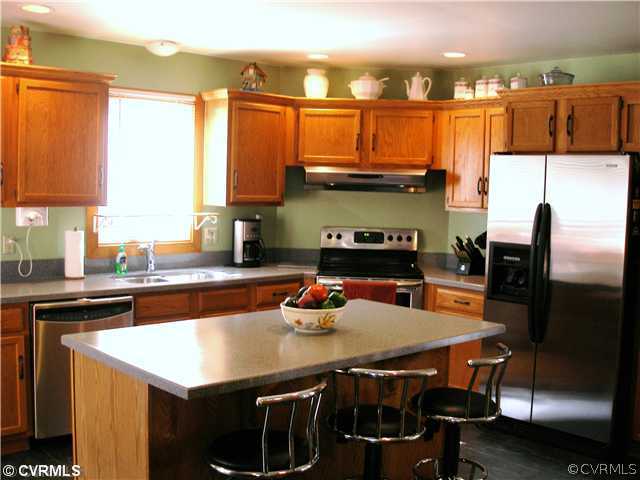 14206 Spring Gate Road Midlothian, VA 23112 - Photo 3 of 10 a kitchen with a table chairs and a refrigerator