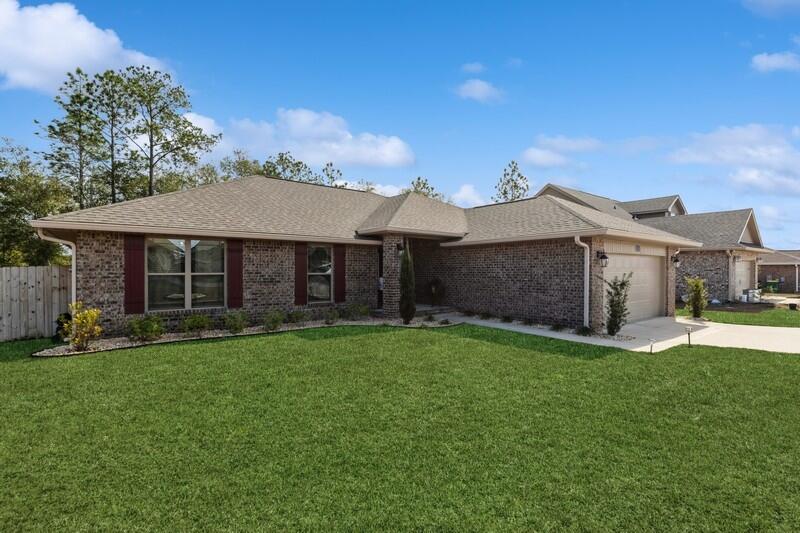 5739 Marigold Loop Crestview, FL 32539 - Photo 9 of 36 a front view of a house with a garden and yard