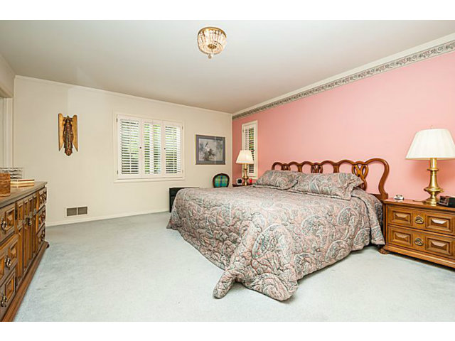 39 De Sabla Road San Mateo, CA 94402 - Photo 17 of 25 a spacious bedroom with a bed and a lamp