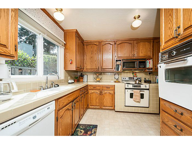 39 De Sabla Road San Mateo, CA 94402 - Photo 8 of 25 a kitchen with stainless steel appliances granite countertop a sink stove and microwave