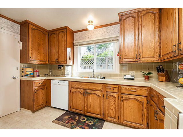 39 De Sabla Road San Mateo, CA 94402 - Photo 9 of 25 a kitchen with stainless steel appliances granite countertop a sink cabinets and a window