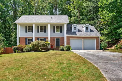 a front view of a house with yard and green space