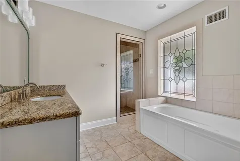 a spacious bathroom with sink shower and bathtub