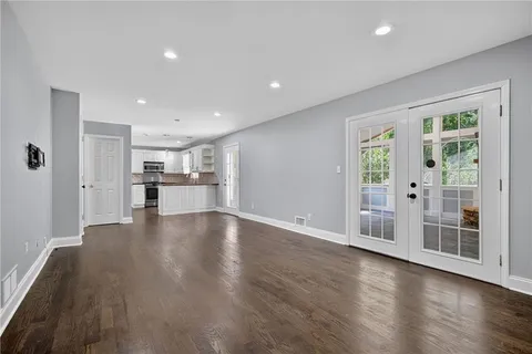 a view of empty room with wooden floor and windows