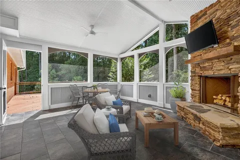 a living room with furniture large windows and a fireplace