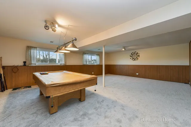 a room with pool table and windows
