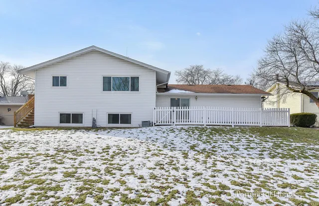 a view of a white house with a yard covered in snow