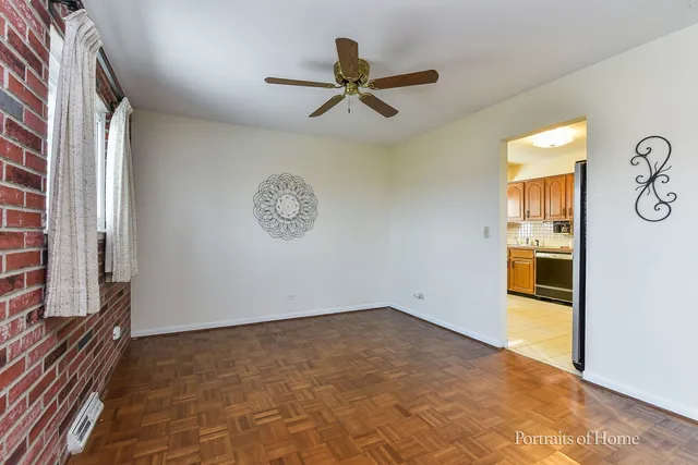 a view of a big room with wooden floor and windows