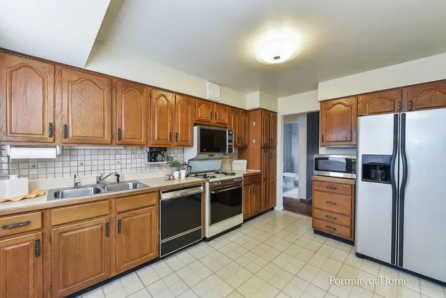 a kitchen with cabinets stainless steel appliances and a sink