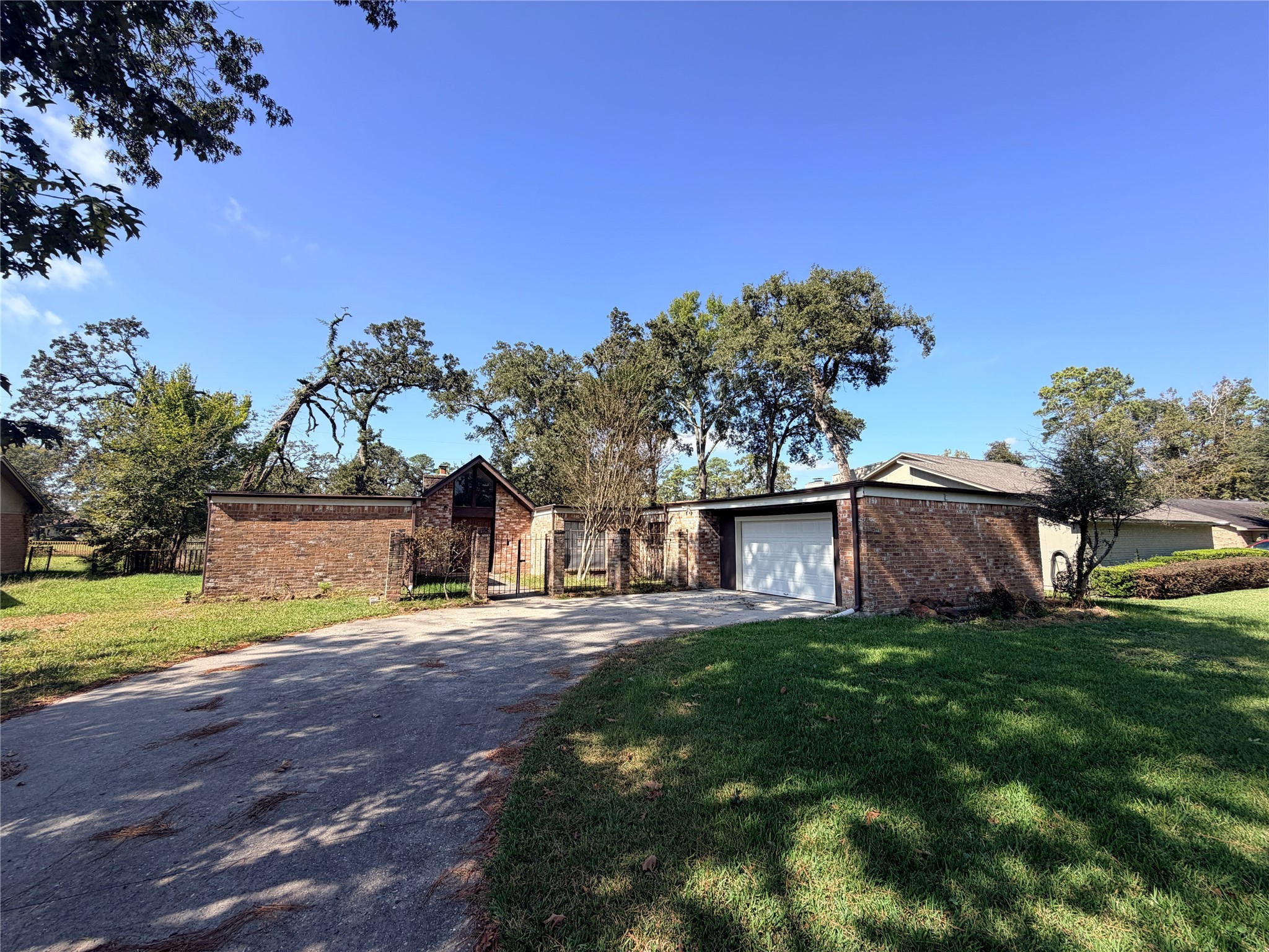a view of a house with a big yard and large trees