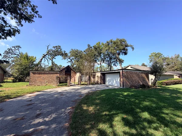 a view of a house with a big yard and large trees
