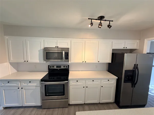 a kitchen with stainless steel appliances white cabinets and a sink