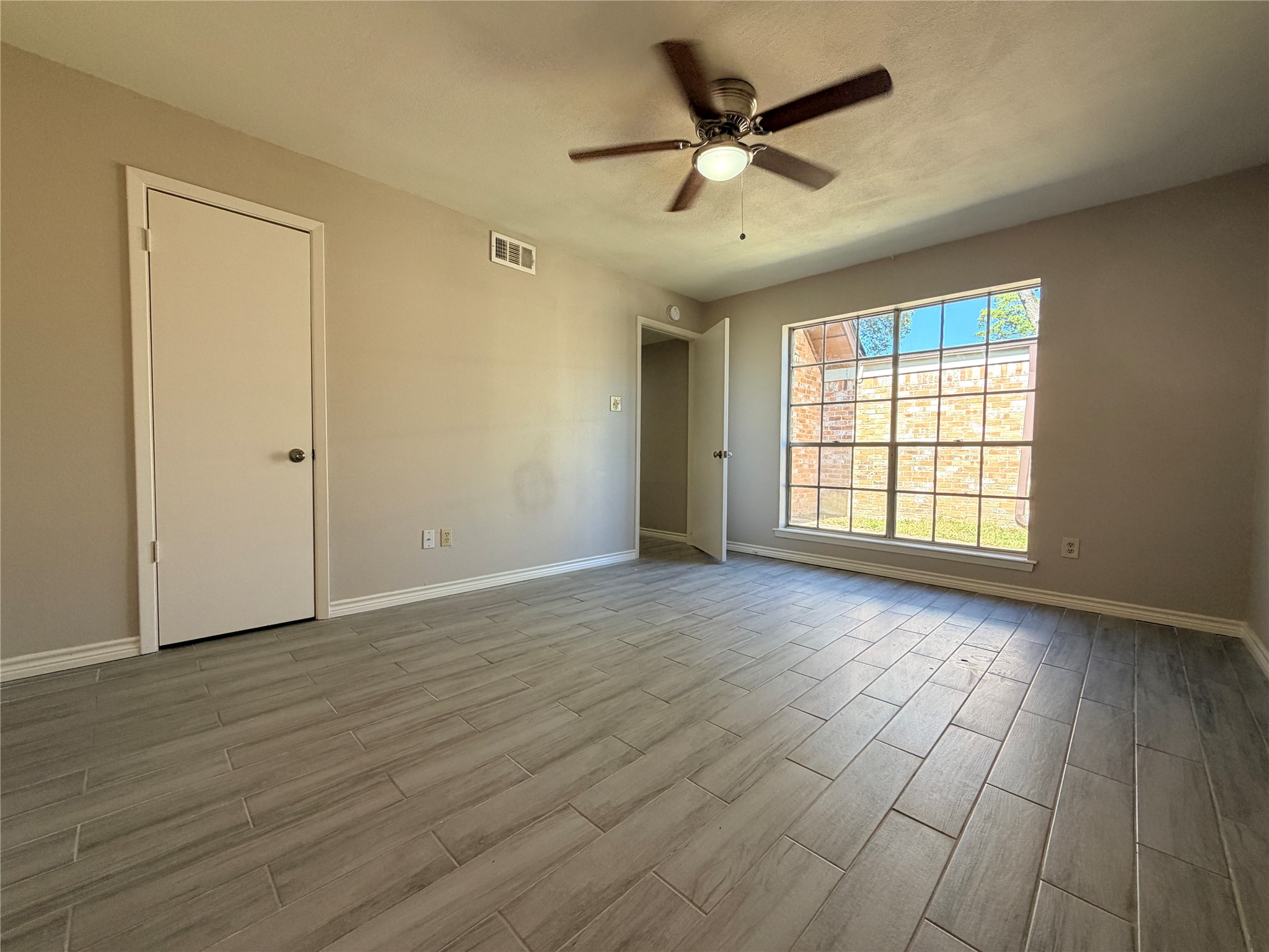 1607 Chestnut Ridge Road Houston, TX 77339 - Photo 14 of 31 an empty room with wooden floor and windows