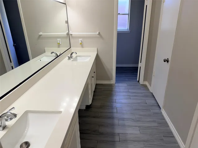 a hallway with wooden floor washer and dryer