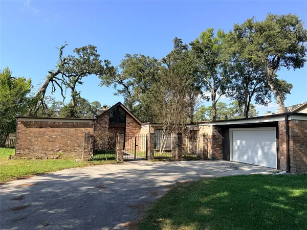a front view of a house with a garden and tree