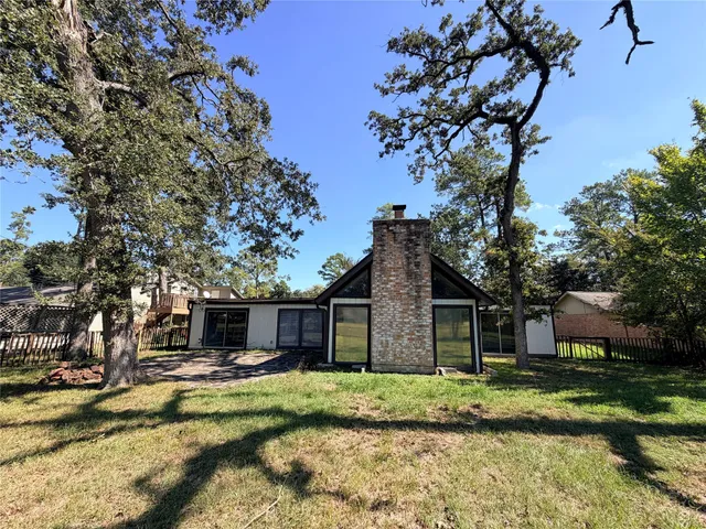 a view of a house with a yard and large tree