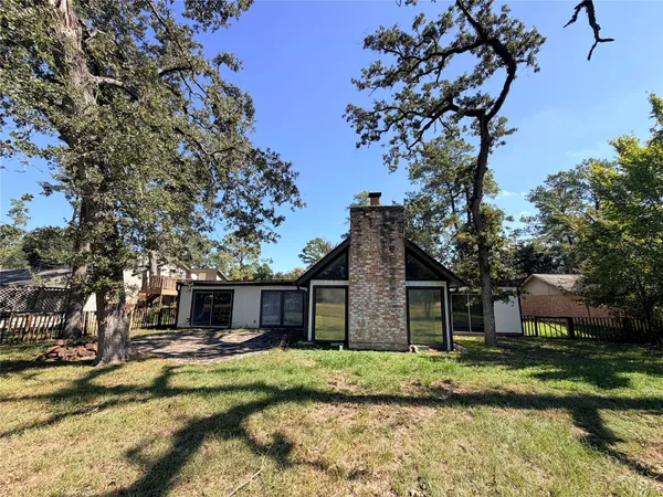 a view of a house with a yard and large tree