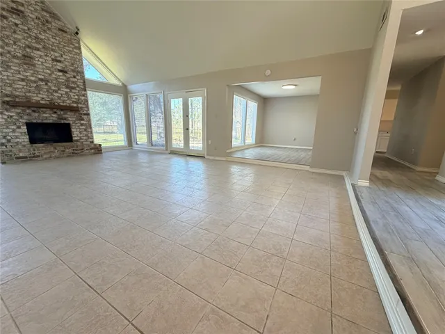 a view of an empty room with fireplace and a window