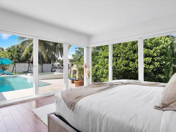 a bedroom with a bed and a large window with outer view