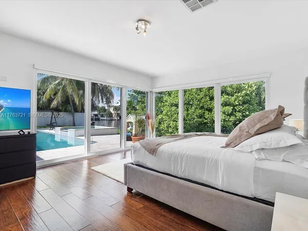 a bed sitting in a bedroom next to a large window