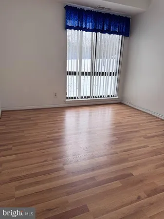 a view of a room with wooden floor and a window