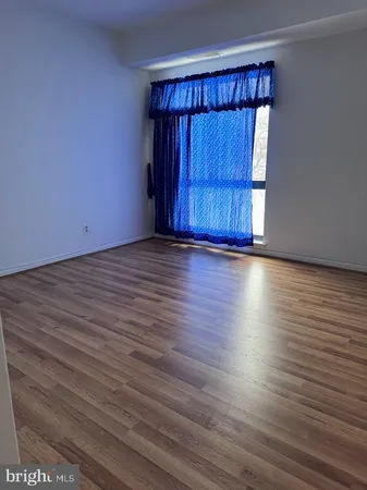 a view of a room with wooden floor and windows
